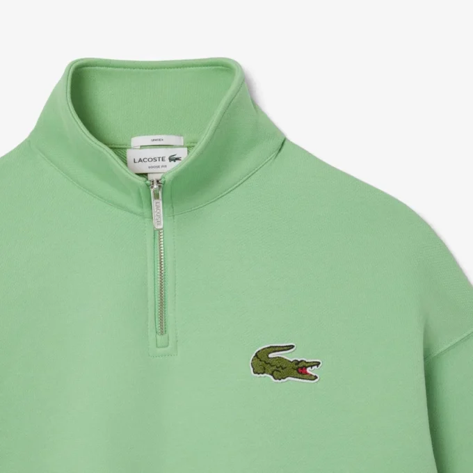 Unisex-sweatshirt med løs passform, badge-detaljer og halv glidelås